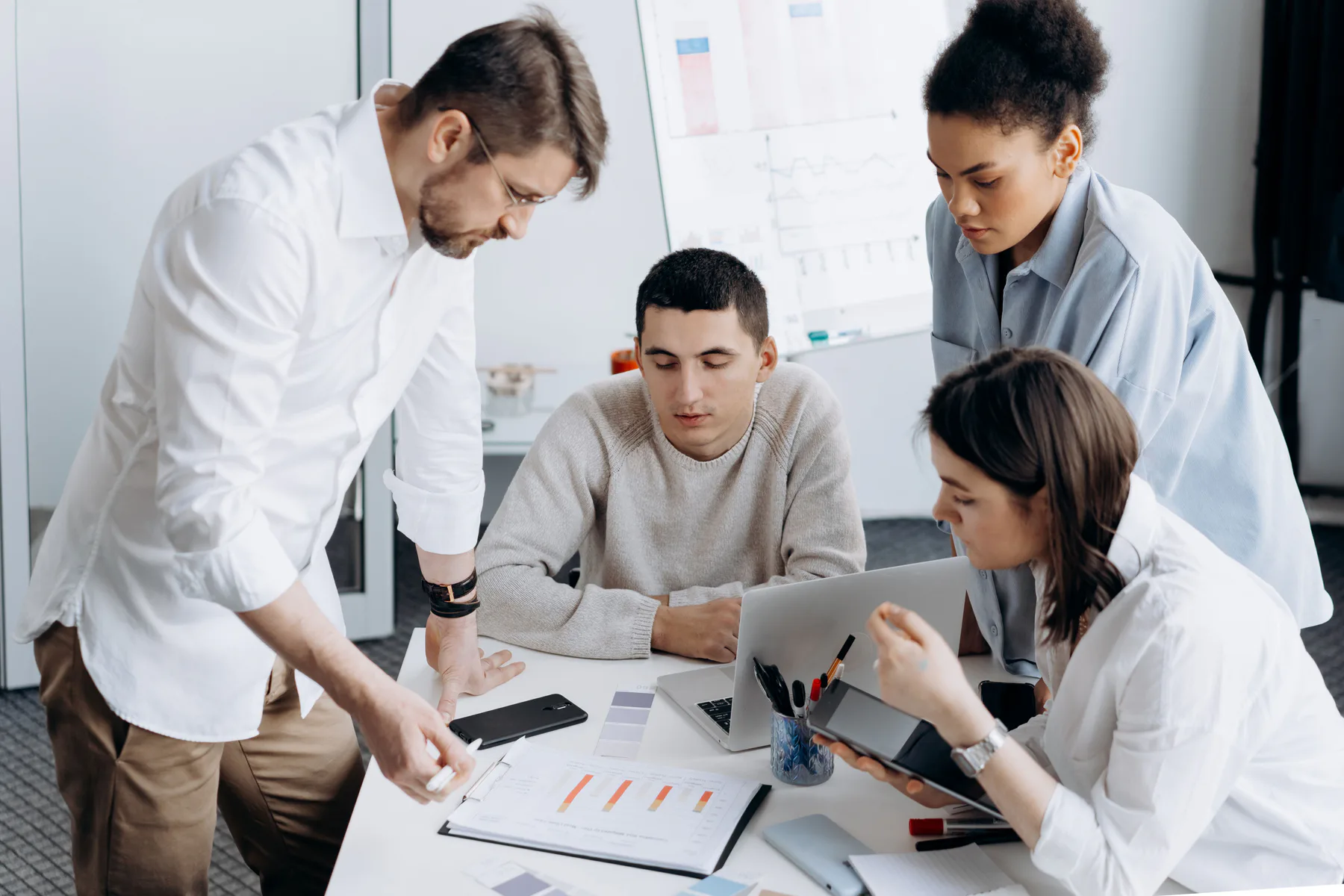 Professionals reviewing project information around a workspace
